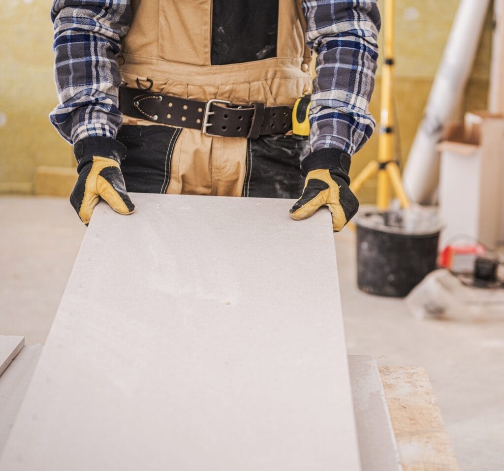 Male Contractor Holding Piece Of Drywall Material. Drywall Process. Sheetrock - drywall